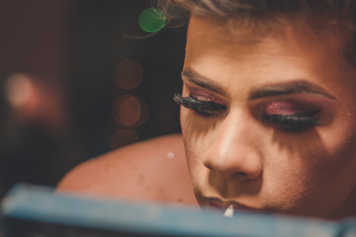 Person applying vibrant pink glitter eyeshadow to their eyes.